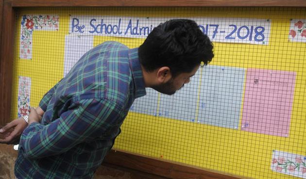 Parents checking the nursery admission list at private school in Delhi. 25% seats are reserved for students belonging to EWS category in each private school. (Burhaan Kinu/HT Photo)