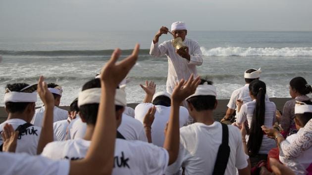 A Balinese Hindu priest sprinkles water on people as they pray. (Agung Parameswara/REUTERS) A Balinese Hindu priest sprinkles water on people as they pray. (Agung Parameswara/REUTERS)