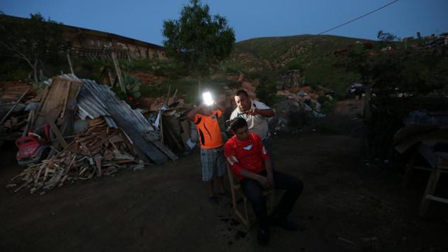 Mexican carpenter Porfirio, 68, cuts his son's hair outside their home near the border fence separating Mexico and the United States, on the outskirts of Tijuana, Mexico. (Edgard Garrido/REUTERS) Mexican carpenter Porfirio, 68, cuts his son's hair outside their home near the border fence separating Mexico and the United States, on the outskirts of Tijuana, Mexico. (Edgard Garrido/REUTERS)