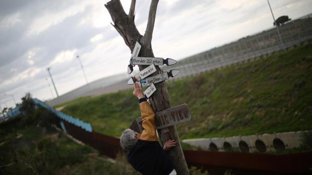 Mexican architect Carlos Torres, 68, adjusts signs near the double border fences separating Mexico and the United States. (Edgard Garrido/REUTERS) Mexican architect Carlos Torres, 68, adjusts signs near the double border fences separating Mexico and the United States. (Edgard Garrido/REUTERS)