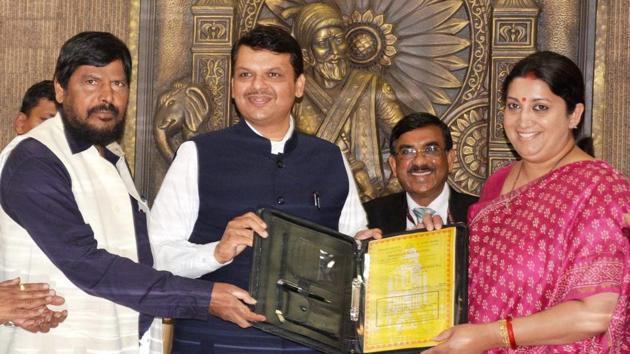 Union textiles minister Smriti Irani (right) hands over land documents to CM Devendra Fadnavis and minister of state for social justice Ramdas Athawale at Vidhan Bhavan on Saturday.(PTI)