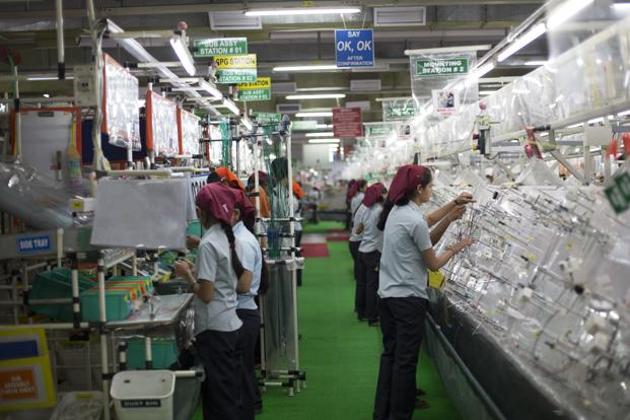A file photo of workers assembling wire harnesses at the Motherson Sumi Systems Ltd. wiring harness plant in Faridabad.(Bloomberg)