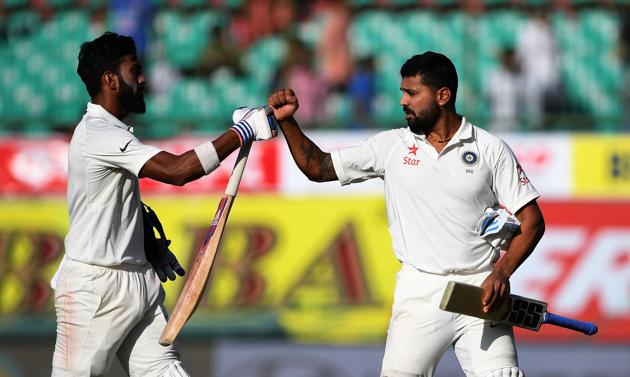 Lokesh Rahul (L) and Murali Vijay fist bump as they walk back to the pavilion at the end of the third day of the fourth and last Test between India and Australia in Dharamsala on Monday. Live streaming and live cricket score of the India vs Australia Test is available online. Details here(AFP)