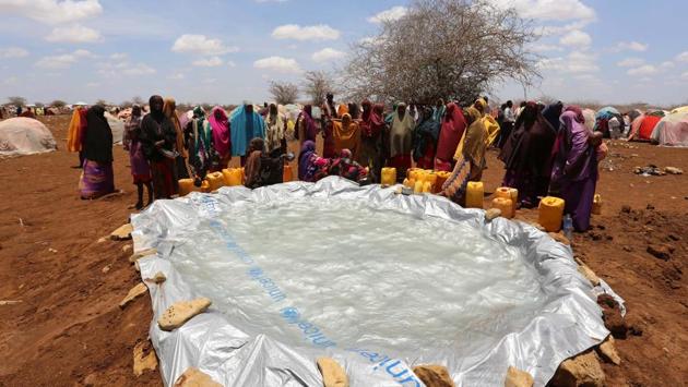 Internally displaced Somali women gather to collect water from a plastic pan near a makeshift camp in Baidoa. Water scarcity also remains a major problem among the new arrivals in the refugee camps. (Feisal Omar/REUTERS)