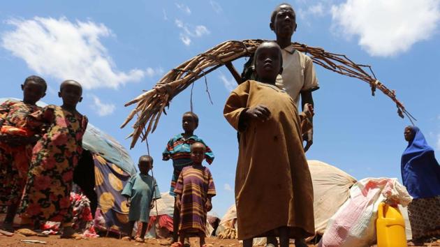Internally displaced Somali people are seen outside their shelter after fleeing from drought stricken regions at a makeshift camp in Baidoa. The hospital ward is filled with the sound of crying, malnourished children, many fed through tubes in their noses. (Feisal Omar/REUTERS)