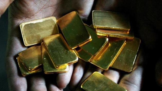 A worker shows gold biscuits at a precious metals refinery in Mumbai.(Reuters photo)