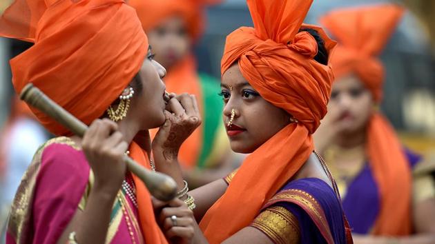 A girl helps another one deck up for a rally in Jogeshwari. (Satish Bate/HT ) 