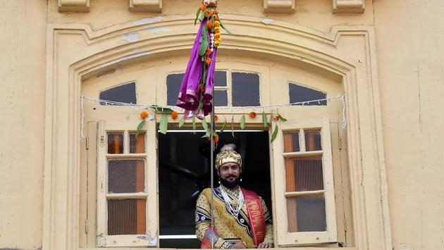 A man dressed in traditional attire watches the procession from his balcony in Girgaum. (Kunal Patil/HT Photo) 