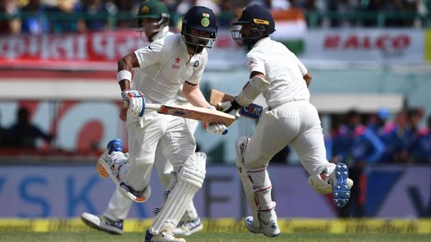 Ajinkya Rahane (R) and Lokesh Rahul run between the wickets on Day 4 of the fourth and final cricket Test match between India and Australia in Dharamsala on Tuesday. India won the match by eight wickets. India clinched the series 2-1. Get full cricket scorecard of India vs Australia fourth Test here.(AFP)