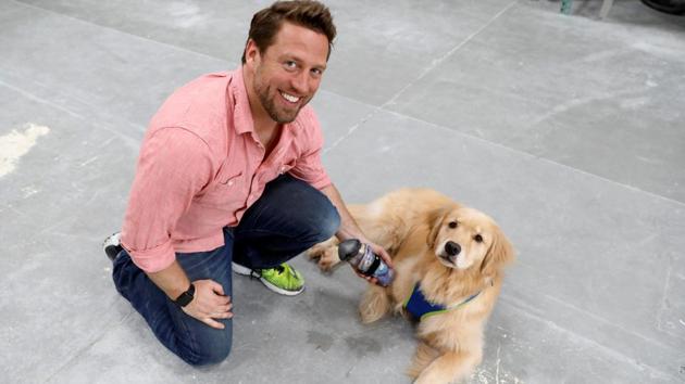 Derrick Campana hold the prosthetic paw he made for Kenna, a three year-old golden retriever born without a front paw. (Kevin Lamarque / Reuters) 