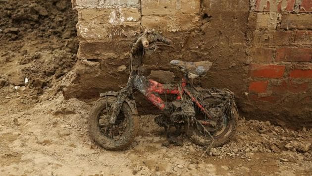 A children's bike leans against a wall covered in mud after rivers breached their banks. (Mariana Bazo/REUTERS)