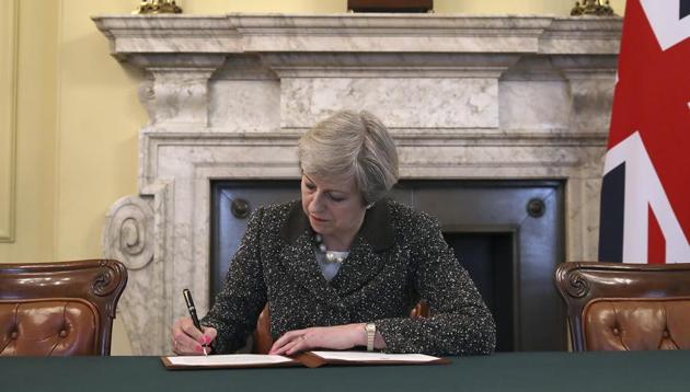 Britain's Prime Minister Theresa May signs the official letter to European Council President Donald Tusk, in 10 Downing Street, London, Tuesday March 28, 2017, invoking Article 50 of the bloc's key treaty, the formal start of exit negotiations.(AP)