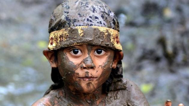 A Balinese boy puts mud on his body during a mud bath tradition known as Mebuug-buugan, in Kedonganan village, near Denpasar on Indonesia's resort island of Bali . (Sonny Tumbelaka / AFP) A Balinese boy puts mud on his body during a mud bath tradition known as Mebuug-buugan, in Kedonganan village, near Denpasar on Indonesia's resort island of Bali . (Sonny Tumbelaka / AFP)