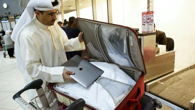 Kuwaiti social media activist Thamer al-Dakheel Bourashed puts his laptop inside his suitcase at Kuwait International Airport in Kuwait City before boarding a flight to the United States on March 23, 2017. Travellers across the Middle East have expressed frustration at a ban on large electronic devices for flights to the United States and Britain that has sparked confusion and speculation.(AFP) Kuwaiti social media activist Thamer al-Dakheel Bourashed puts his laptop inside his suitcase at Kuwait International Airport in Kuwait City before boarding a flight to the United States on March 23, 2017. Travellers across the Middle East have expressed frustration at a ban on large electronic devices for flights to the United States and Britain that has sparked confusion and speculation.(AFP)