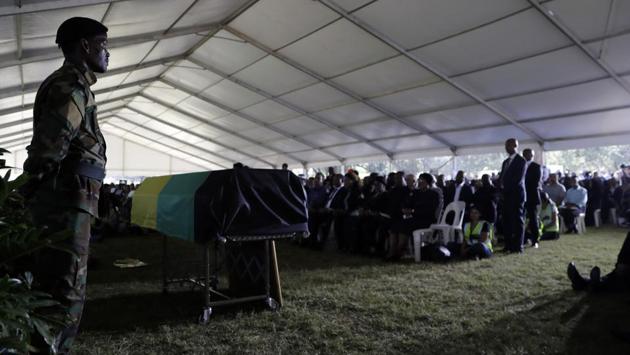 A member of the African National Congress (ANC), stands next to a coffin during the funeral service for Ahmed Kathrada, at West Park Cemetery in Johannesburg. Kathrada died at a Johannesburg hospital after being admitted for surgery linked to blood clotting on the brain.  (Themba Hadebe/AP) 