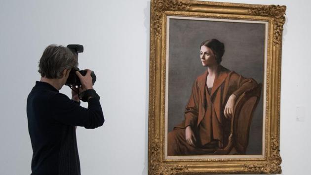 A man takes a picture of Spanish artist Pablo Picasso's painting ‘Olga Picasso’ displayed at the exhibition ‘Picasso, Portraits’ organised at the Picasso Museum in Barcelona on March 16.(AFP)