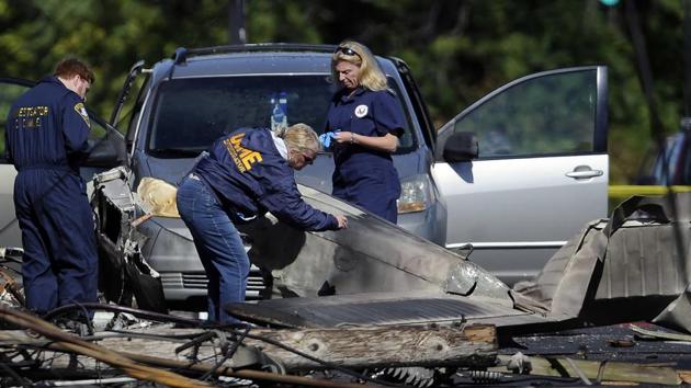 Investigators look at the remains of a small plane along Main Street in East Hartford, Connecticut.(AP File Photo)