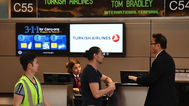 A passenger talks with a Turkish Airlines manager beside a check-in counter at Los Angeles International Airport in Los Angeles, California. (AFP Photo)