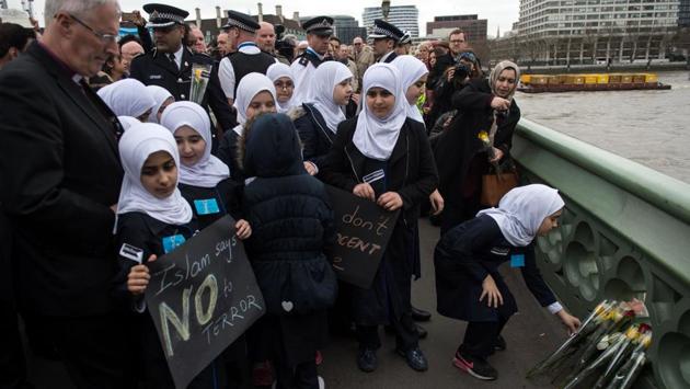 Police officers and members of faith groups lay flowers during a vigil on Westminster Bridge.  (Oli Scarff/AFP) 