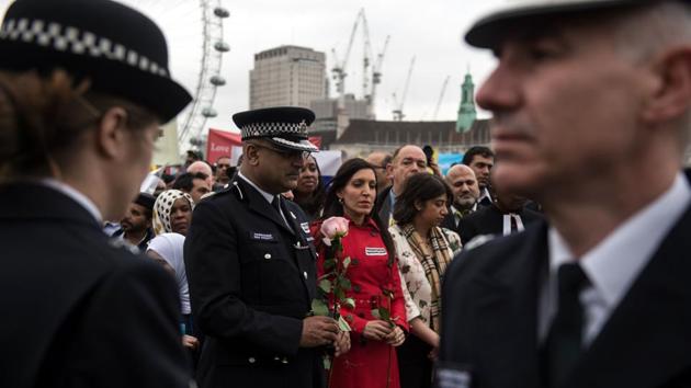Police officers, members of the public and faith groups take part in a vigil. (Oli Scraff/AFP) 
