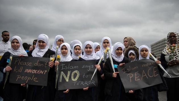 Muslim children seen holding posters during the vigil. The mourners also observed a minute’s silence at the very moment on March 22 when Khalid Masood ploughed his car into a crowd in a rampage that killed three people on Westminster Bridge in the shadow of Big Ben. (Oli Scraff/AFP) 