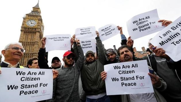People hold posters on Westminster as they gather to mark one week since a man drove his car into pedestrians then stabbed a police officer. Precisely a week before Khalid Masood drove into crowds on the bridge before stabbing a police officer at the nearby Palace of Westminster (Stefan Wermuth/reuters) 