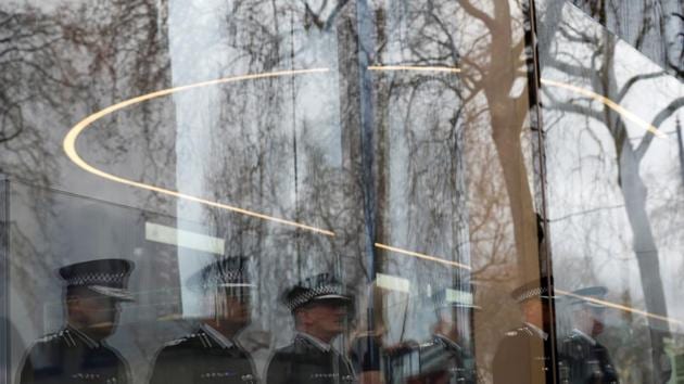 Police officers are reflected in a window as they hold a minute's silence outside New Scotland Yard to mark one week since a man drove his car into pedestrians on Westminster Bridge then stabbed a police officer in London, Britain. (Peter Nicholls/REUTERS) 