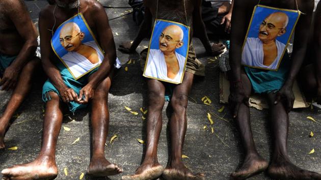 Farmers from Tamil Nadu display posters of Mahatma Gandhi as they sit on protest. (Saumya Khandelwal/HT PHOTO)