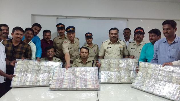 Police officers display the seized notes.(HT photo)