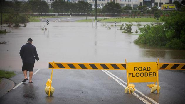 An onlooker looks at submerged cars in a flooded car-park in Toombul, in Queensland. (Patrick Hamilton/AFP) An onlooker looks at submerged cars in a flooded car-park in Toombul, in Queensland. (Patrick Hamilton/AFP)