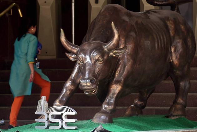 A woman walks past a bronze replica of a bull at the Bombay Stock Exchange as Sensex closed 486 points up, in Mumbai. (PTI) A woman walks past a bronze replica of a bull at the Bombay Stock Exchange as Sensex closed 486 points up, in Mumbai. (PTI)