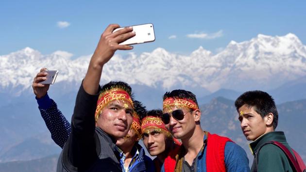 Young locals from Garhwal engage in shooting selfies at the temple. (Gurinder Osan/HT Photo)
