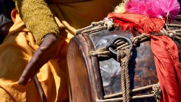 A percussionist from a nearby village, plays his drum, the sound of which is carried to all neighbouring villages to announce continuing festivities on an auspicious day at the Kartik Swami Temple. (Gurinder Osan/HT Photo)