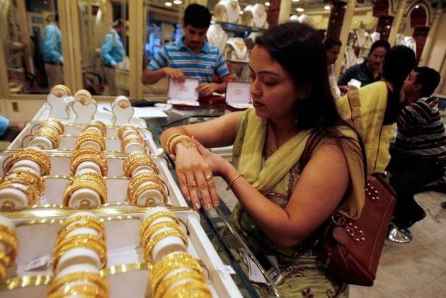 A woman tries on a gold bracelet at a jewellery showroom.(REUTERS)