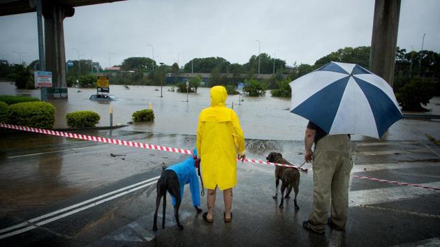 Onlookers look at submerged cars in a flooded car-park in Toombul, in Queensland. Torrential rain hampered relief efforts after powerful cyclone Debbie wreaked havoc in northeast Australia, with floods sparking emergency rescues as fed-up tourists began evacuating from resort islands. (Patrick Hamilton/AFP) Onlookers look at submerged cars in a flooded car-park in Toombul, in Queensland. Torrential rain hampered relief efforts after powerful cyclone Debbie wreaked havoc in northeast Australia, with floods sparking emergency rescues as fed-up tourists began evacuating from resort islands. (Patrick Hamilton/AFP)