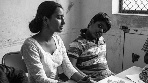 Dravid sits next to his one of his care givers after finishing his session of coloring. (Vageesh Lall/ HT Photo)