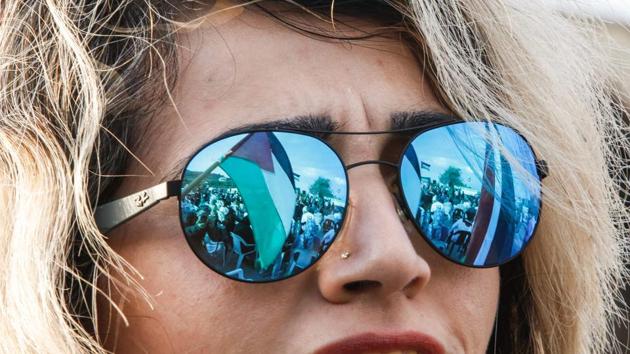 A picture taken on March 30, 2017 shows a reflection through the lenses of a female demonstrator's sunglasses of a Palestinian flag flying during a demonstration of Arab-Israelis marking Land Day in the northern Arab-Israeli village of Deir Hanna in the northern Galilee region. (HAZEM BADER / AFP)
