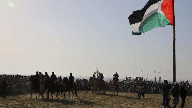 Bedouin youths ride their camels and horses during a rally marking the 41st anniversary of Land Day, in Deir el-Balah, Central Gaza Strip. (Adel Hana / AP)