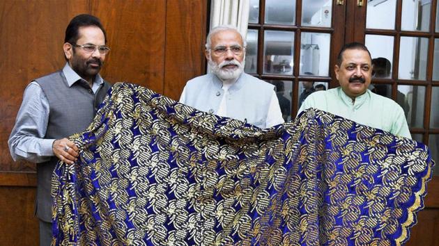 Prime Minister Narendra Modi hands over a chaadar to be offered at Dargah Khwaja Moinuddin Chishti at Ajmer Sharif to Union ministers Mukhtar Abbas Naqvi and Jitendra Singh.(PTI)