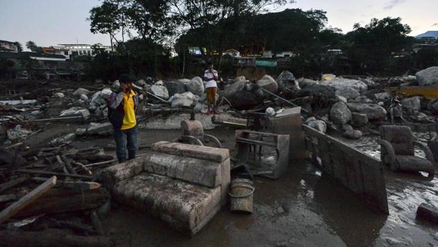 A man talks on his mobile phone amid the rubble left by mudslides following heavy rains, in Mocoa. Mocoa was left without power or running water, and there were reports of people looting stores in search of bottled water. (Luis Robayo/AFP)