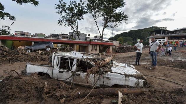 People look at the damages caused by mudslides. A landslide in November killed nine people in the rural southwestern town of El Tambo, officials said at the time. (Luis Robayo/AFP)