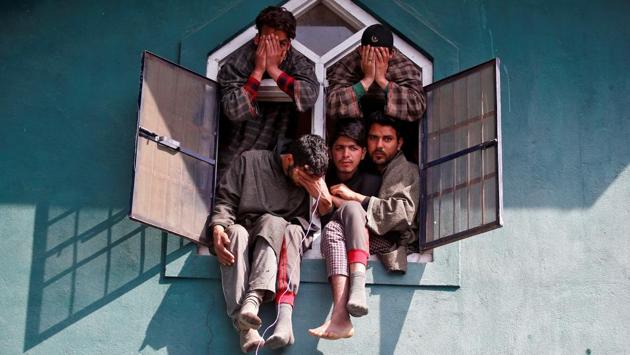 People react as they sit in a window of a mosque during the funeral of Tauseef Ahmad Wagay, a suspected militant, who according to local media was killed in a gun battle with Indian army on Tuesday in Chadoora, in Yaripora, in south Kashmir’s Kulgam district on March 29, 2017. (Danish Ismail/REUTERS)