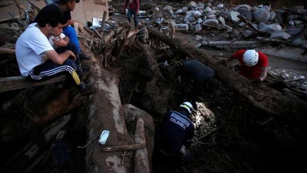 Rescue agencies look for bodies in a destroyed area after heavy rains caused several rivers to overflow. A landslide the month before killed 10 people in the north of the country. (Jaime Saldarriaga/Reuters)