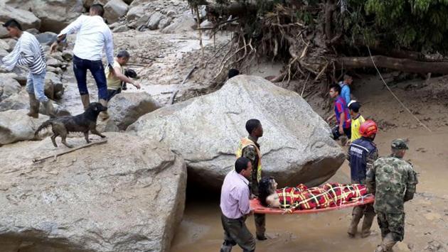 Rescuers carry a woman after heavy rains caused a nearby river to overflow and surge mud and debris into Mocoa. Climate change can play a big role in the scale of natural disasters, such as this one, a senior UN official said. (NYT)