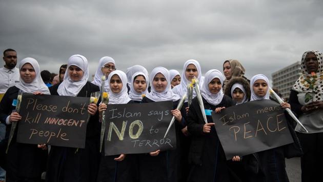 TOPSHOT - Muslim children take part in a vigil on Westminster Bridge in central London on March 29, 2017 to commemorate one-week since the March 22 terror attack that killed four. Four people were killed and scores more injured after British man Khalid Masood ploughed a speeding vehicle through a crowd of pedestrians and fatally stabbed policeman Keith Palmer just inside the gates of the British parliament before being shot dead himself in a frenzied attack lasting just 82 seconds on March 22. / AFP PHOTO / OLI SCARFF (AFP)