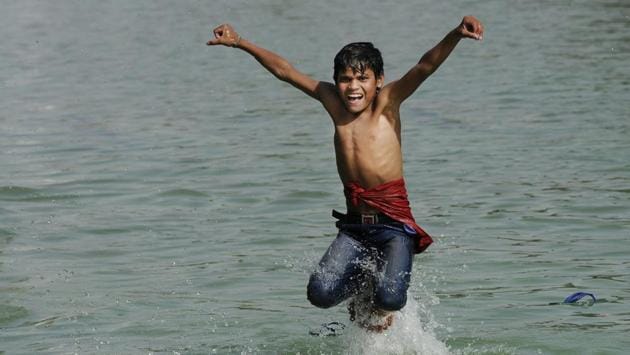 A boy jumps into a water channel near India Gate to get respite from the heat in New Delhi, India on March 29, 2017. (Burhaan Kinu/HT PHOTO)