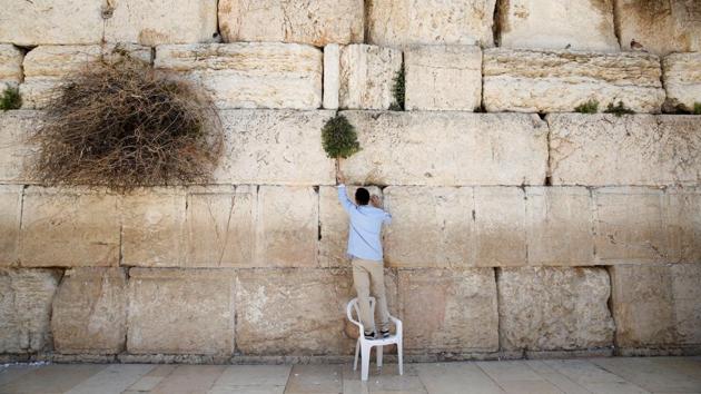 A man clears notes placed in the cracks of the Western Wall, Judaism's holiest prayer site, to make space for new notes ahead of the Jewish holiday of Passover, in Jerusalem's Old City on March 29, 2017. (Baz Ratner /REUTERS)