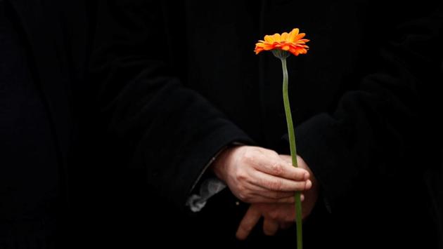 A Muslim man holds a flower as he stands in line with others on Westminster Bridge during an event to mark one week since a man drove his car into pedestrians then stabbed a police officer in London, Britain on March 29, 2017. (Stefan Wermuth/REUTERS)