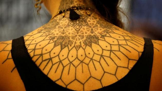 A woman shows her tattoo on her back. (Navesh Chitrakar / Reuters)
