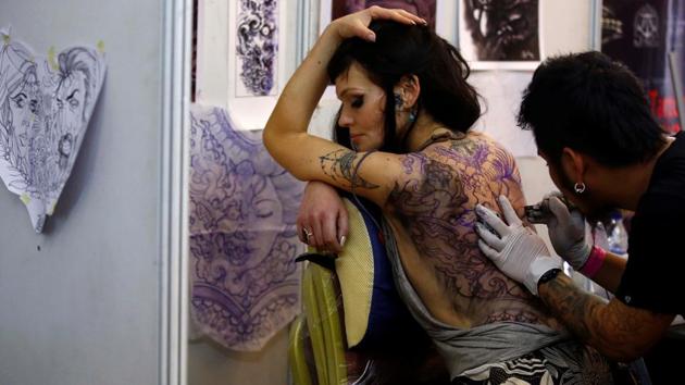 A woman gets a tattoo on her back during the Nepal Tattoo Convention. (Navesh Chitrakar / Reuters)